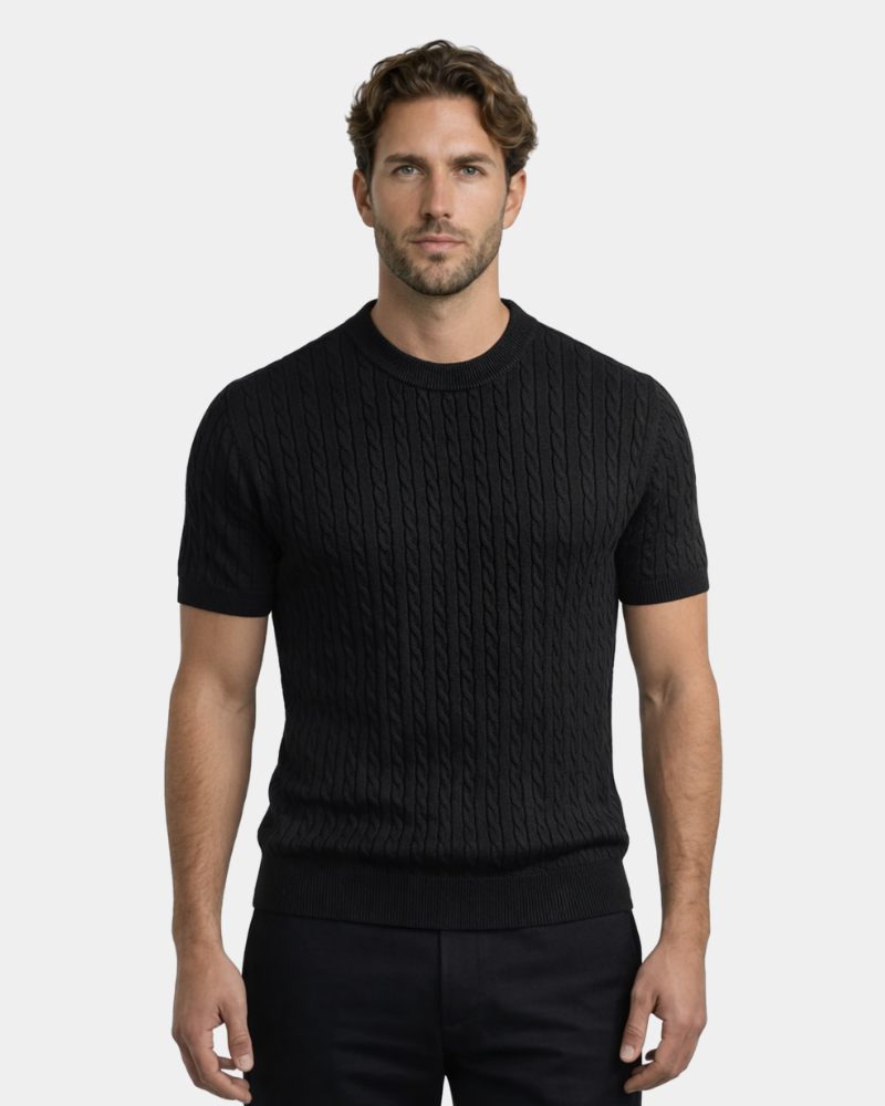 A man in a black cotton cable knit t-shirt. Minimalist luxury, textured short-sleeve sweater, tailored fit.