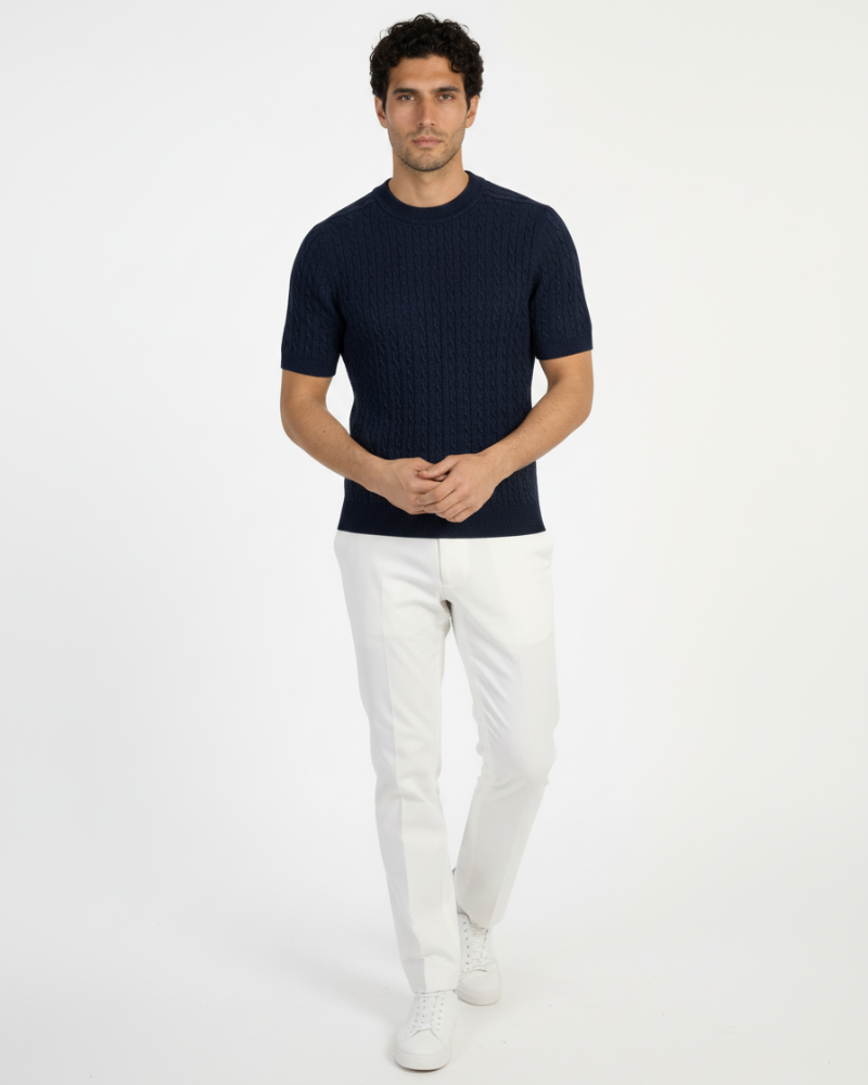 A navy wool-blend cable knit t-shirt with white trousers. Minimalist luxury, slim-fit texture, and timeless style.