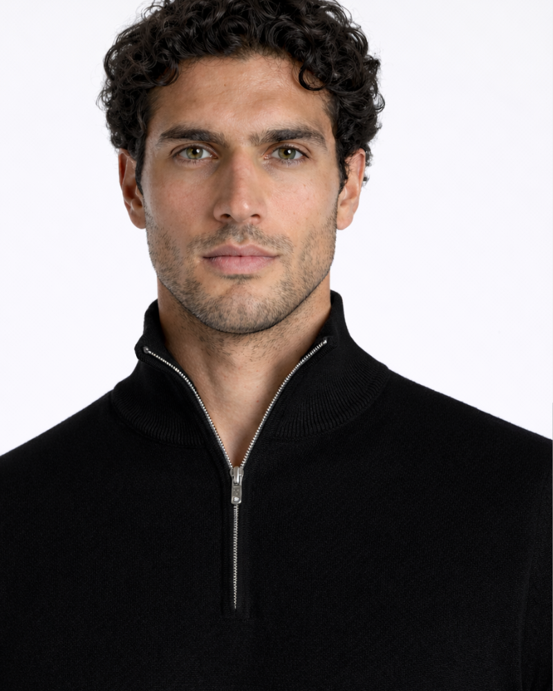 Minimalist luxury black knit half-zip sweater in premium wool. Slim fit with ribbed collar and silver hardware.