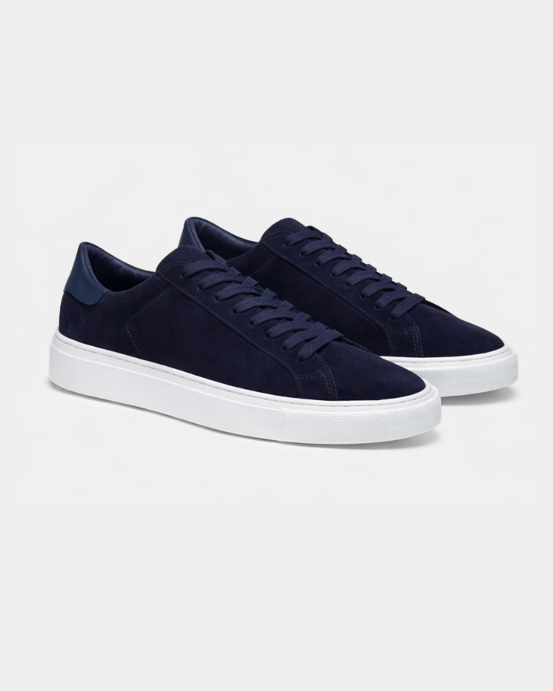 Luxury navy suede trainers with matching flat laces and white midsoles, presented in an elegant angled pair view. #color_navy