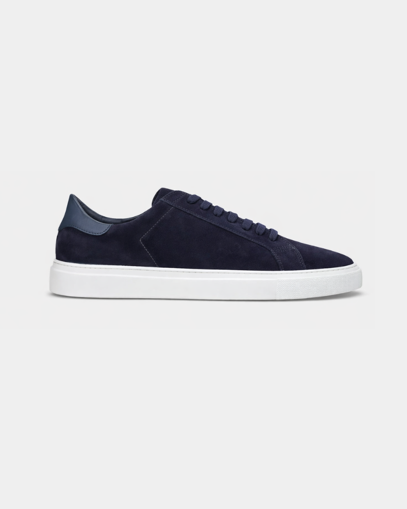 Minimalist luxury navy blue suede trainers featuring a deep blue leather heel tab and a crisp white rubber sole. #color_navy