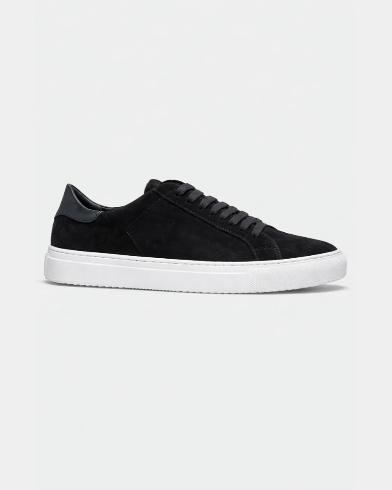 Minimalist luxury black suede trainers with tonal laces, sleek leather heel tab, and premium white rubber cupsole. #color_black