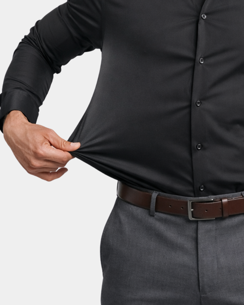 By Alden Black Slim Fit Dress Shirt worn by a White male model, close-up front view showing stretch fabric detail, light grey background #color_black