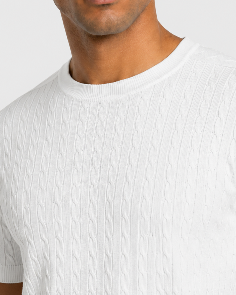 Close-up of a person wearing a By Alden white textured t-shirt against a light background #color_white