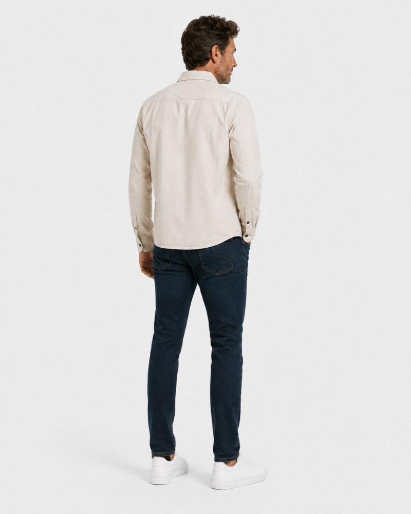 Man wearing a By Alden beige shirt and blue jeans on a white background #color_deep stone