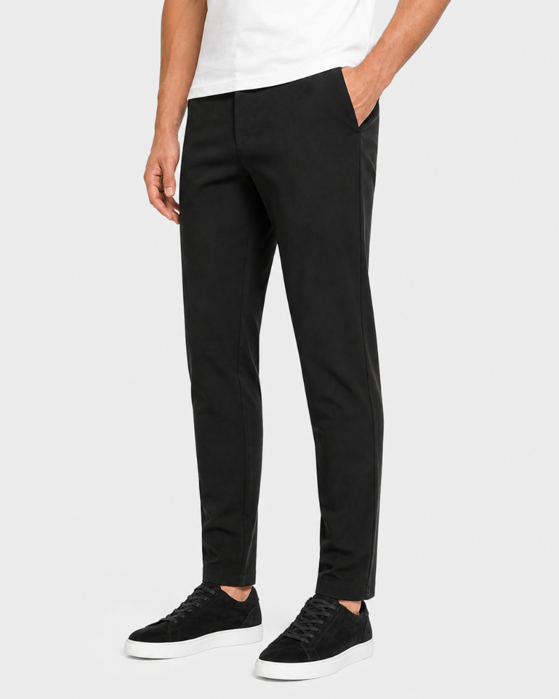 Person wearing By Alden black pants and white sneakers on a white background #Color_black