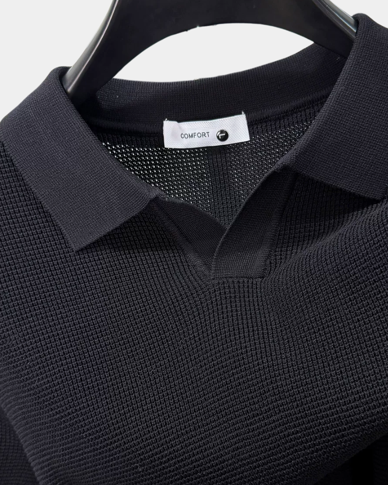By Alden black open-collar knit polo shirt collar and label detail, hanger, close-up, light gray background. #color_black