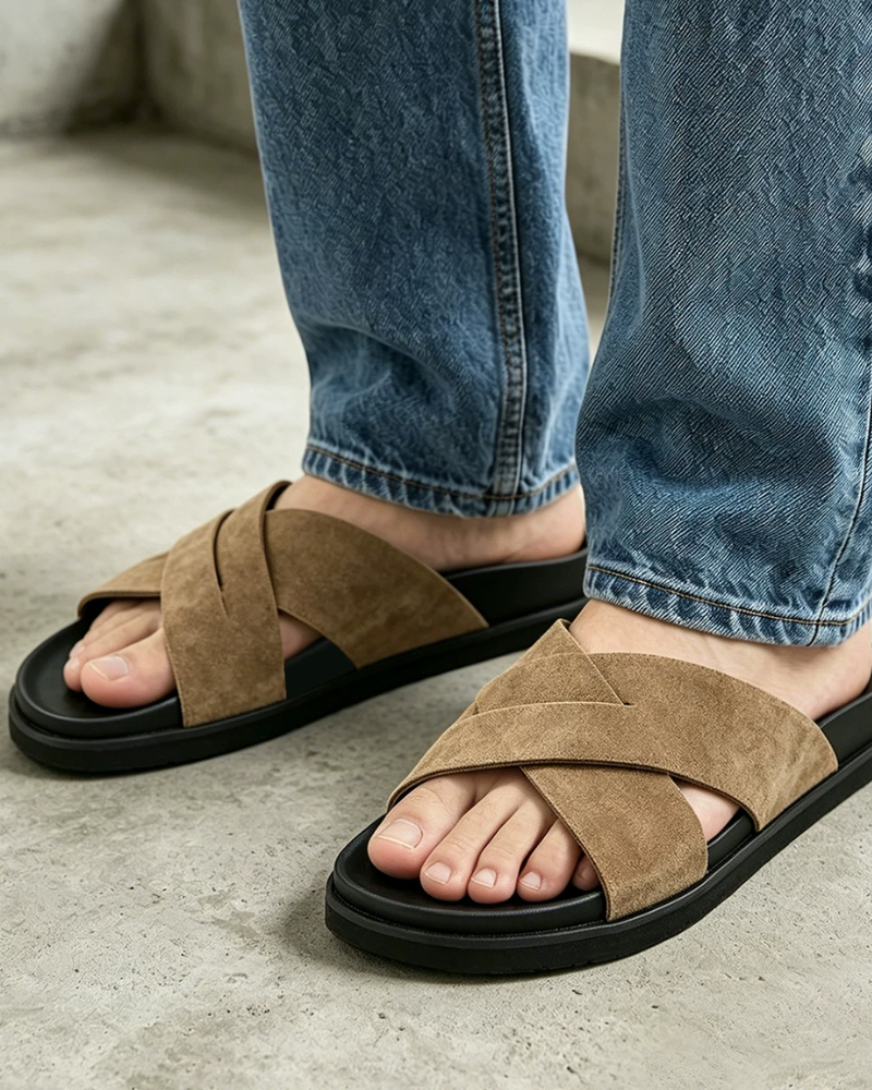 By Alden camel cross-strap suede slide sandal, male Caucasian model, close-up view, concrete background #Color_camel