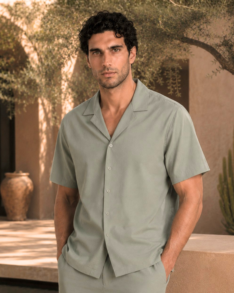 By Alden olive green short-sleeve camp collar shirt on male model, front view, upper body, outdoor beige background.
#Color_olive green