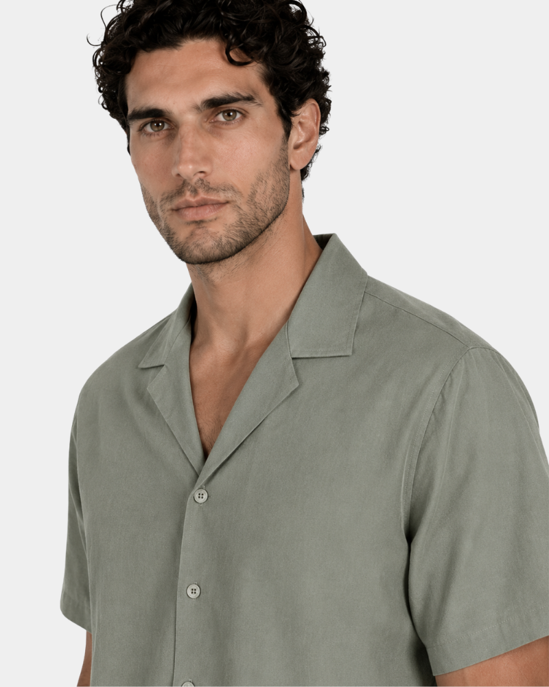 By Alden olive green short-sleeve shirt on male Caucasian model, close-up 3/4 angle, gray bg #Color_olive green