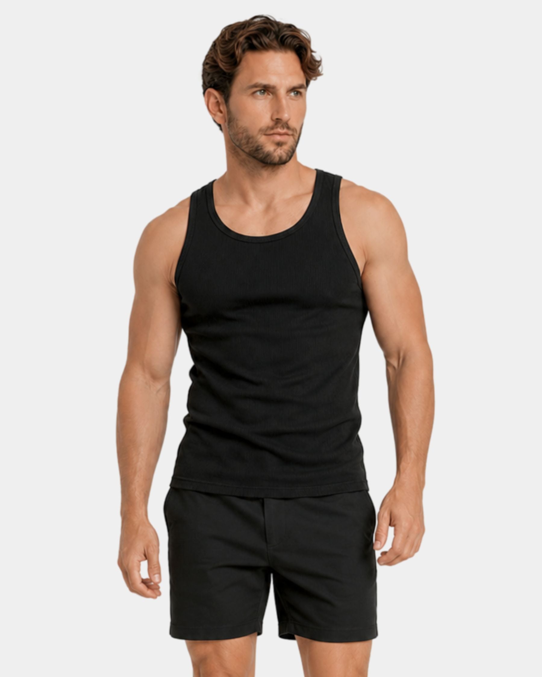 Man wearing a black tank top and shorts on a white background