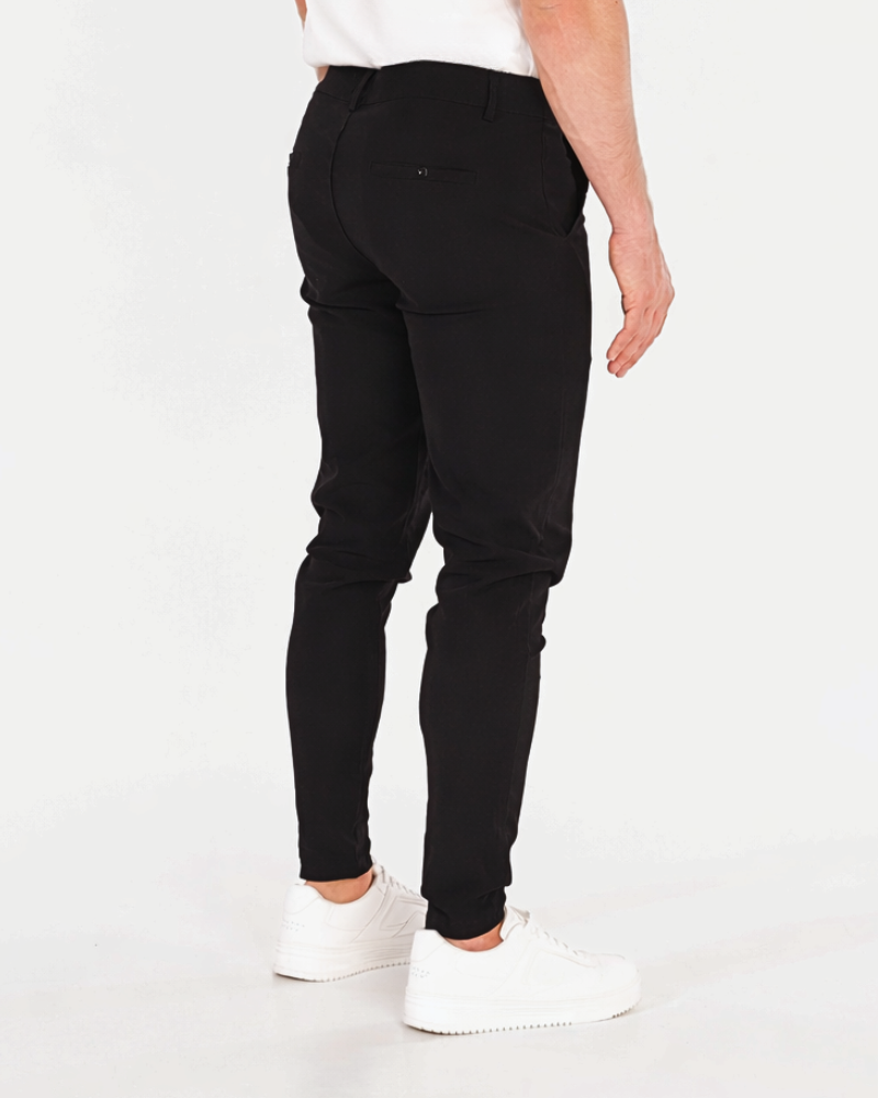 Luxury black stretch cotton chinos featuring a slim minimalist fit and subtle pocket detailing for a clean aesthetic.