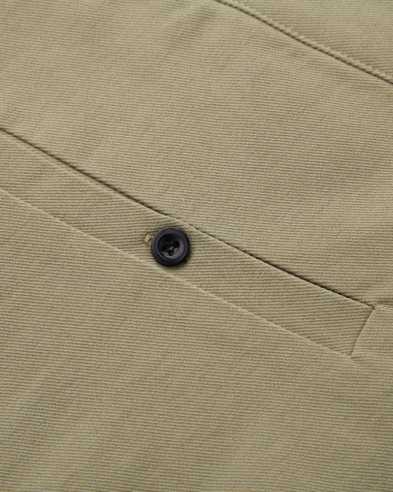 Minimalist luxury olive chinos in a breathable cotton-twill weave, featuring a premium matte black button and welt pocket.