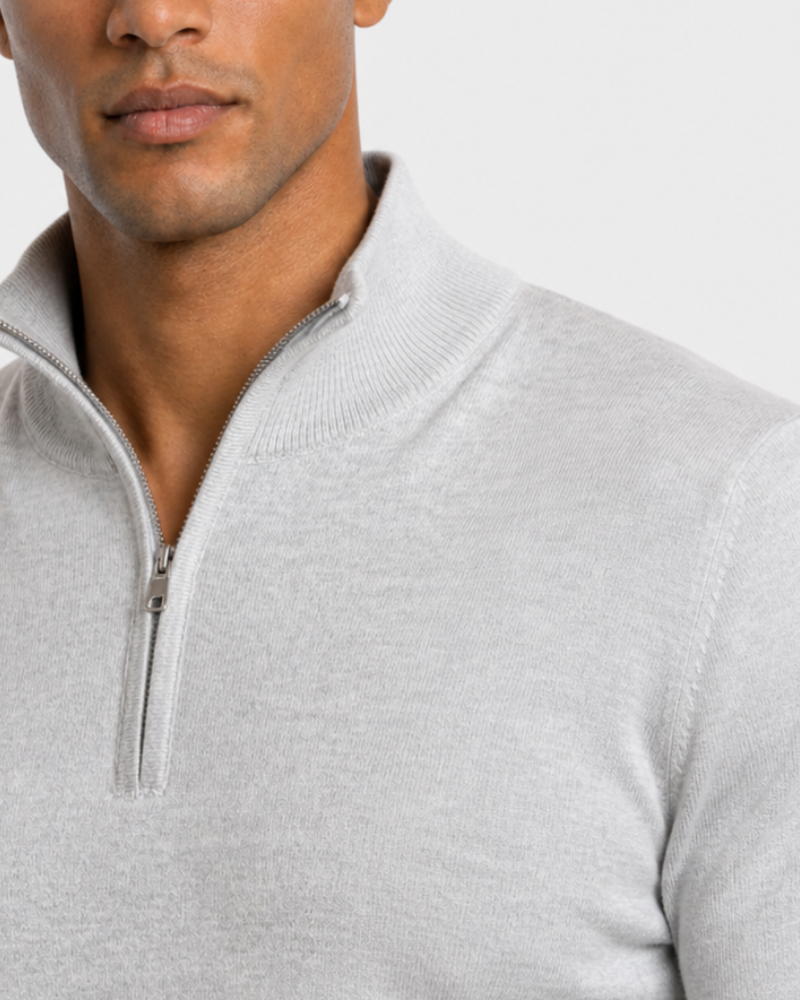 Close-up of a person wearing a By Alden gray quarter-zip sweater on a light gray background #color_gray