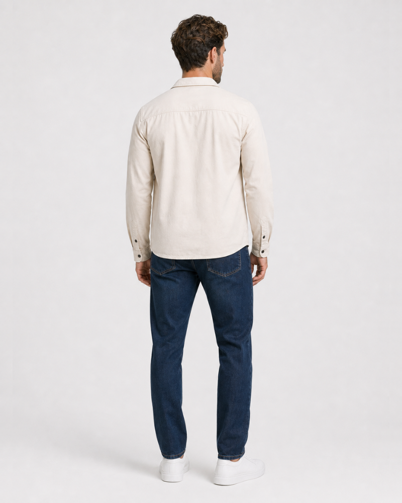 Man wearing a By Alden beige shirt and blue jeans on a white background #color_deep stone