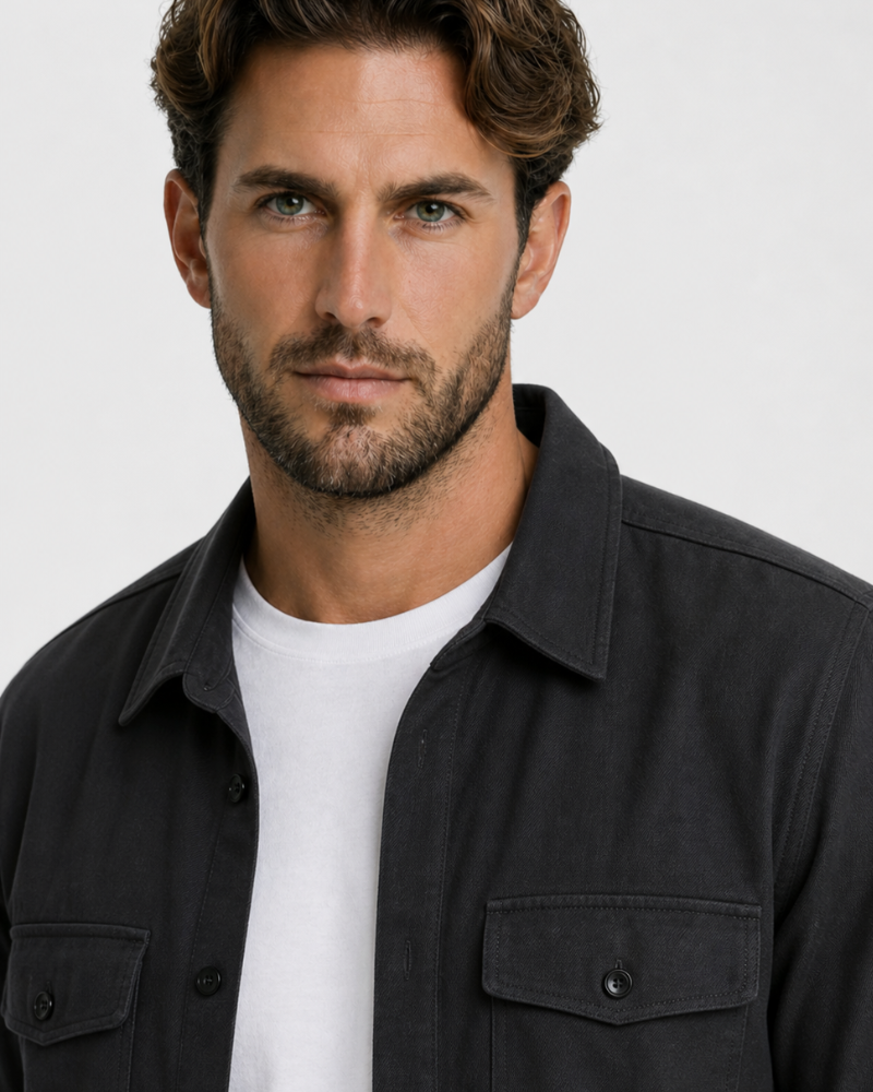 Man wearing a By Alden black jacket over a white shirt on a plain background #color_black