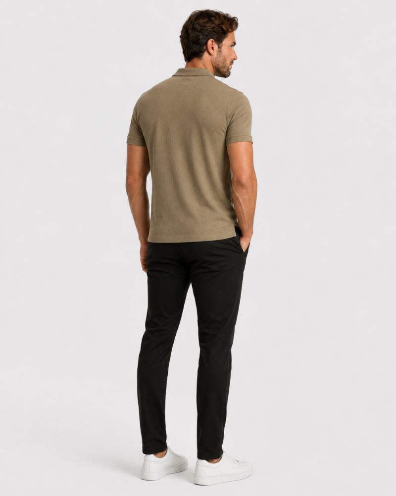 Man wearing a By Alden green polo shirt and black pants on a white background #Color_camel