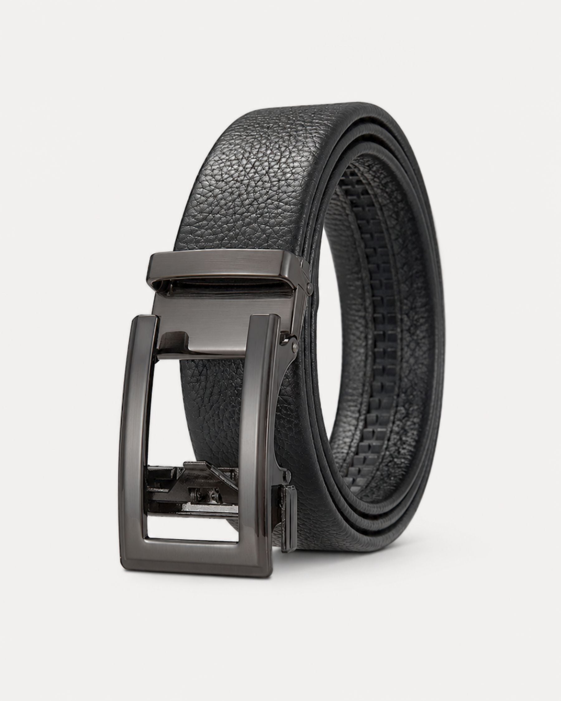 By Alden black leather ratchet belt with gunmetal buckle, product shot, three-quarter view, light gray background. #color_black
