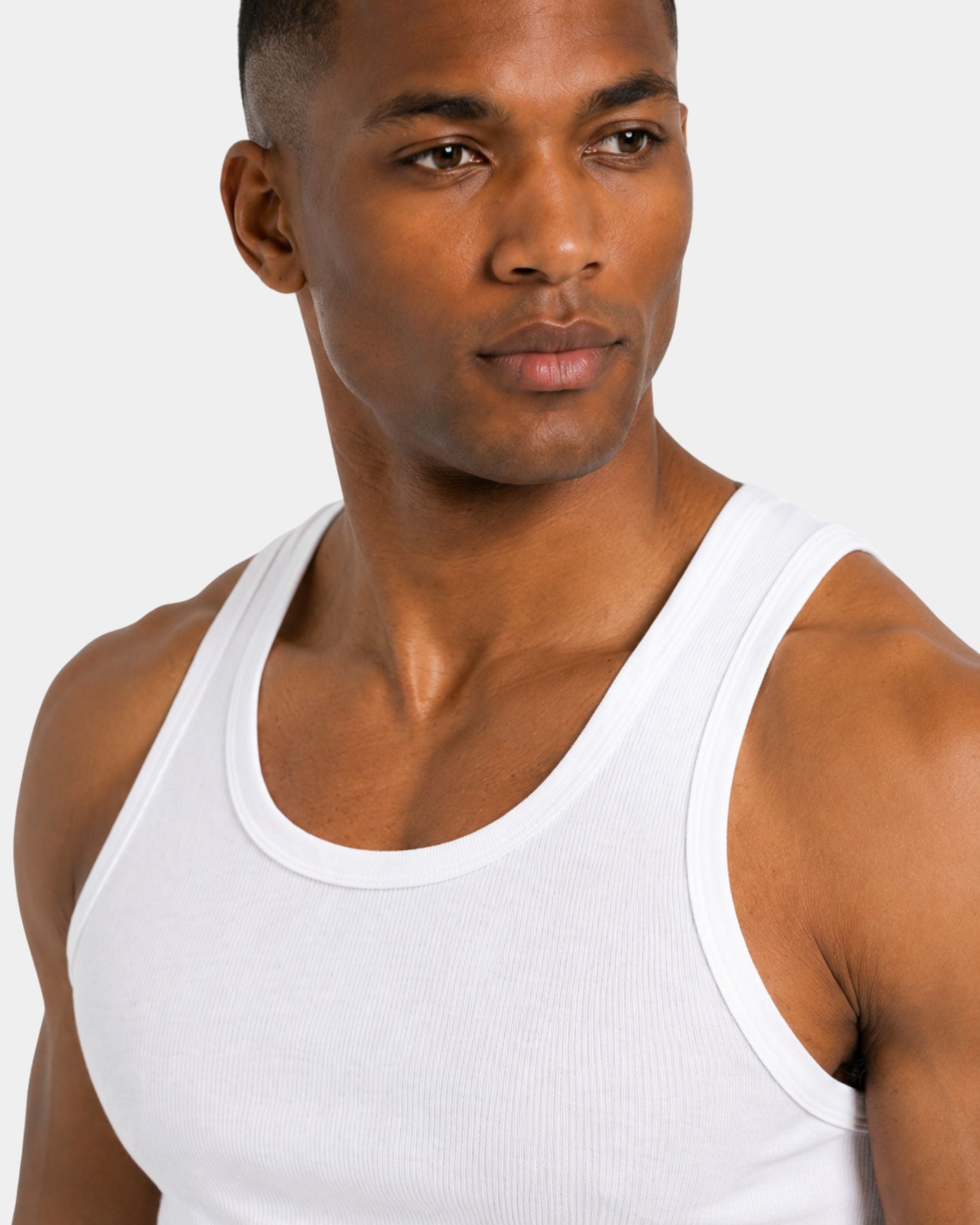 Man wearing a white tank top against a plain background